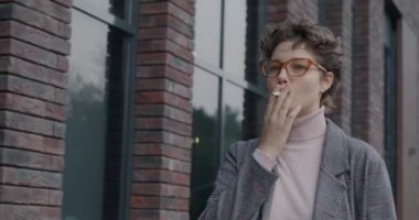 Çekici genç bir kadının gündüz vakti sokakta yürüyüp sigara içişini. Nikotin bağımlılığı ve milenyum konsepti.