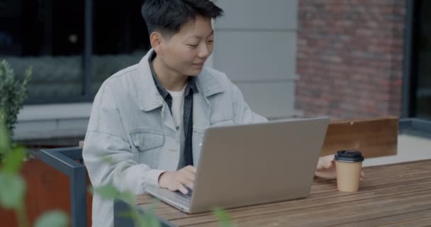 Asyalı Öğrenci Online Okulda Öğreniyor Sokak Kafesinde Oturuyor Dizüstü Bilgisayarla — Stok video