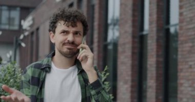 Ortadoğulu kaygısız bir adamın portresi cep telefonuyla konuşuyor, gülümsüyor açık havada konuşuyor. Gündelik iletişim ve akıllı telefon bağlantısı kavramı.