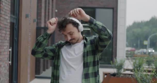 Giocoso Uomo Mediorientale Che Balla Ascoltando Musica Con Cuffie Passeggiando — Video Stock