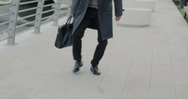 Asyalı iş adamının heyecanla dans etmesi şehirde mutluluğu dışa vurması. Neşeli gençlik ve başarılı iş adamı konsepti.