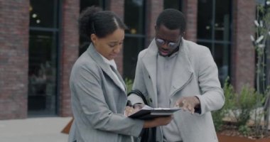 Afrika kökenli Amerikalı iş adamlarının, şehir sokaklarında durmuş mali belgeleri tartışması. İletişim ve ortaklık kavramı.
