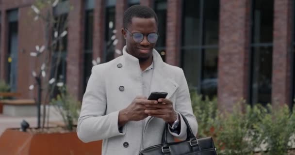 Ritratto Rallentatore Uomo Affari Afroamericano Che Utilizza Messaggistica Smartphone Piedi — Video Stock