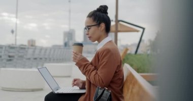 Orta Doğulu iş kadınının laptopla çalışması ve şehirde kahve içmesi. İş ve şehir yaşam tarzı kavramı.