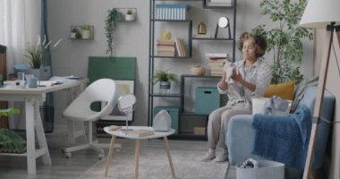 Afro-Amerikalı kadın boş zamanlarında çamaşır sepetine çamaşır yığını koyuyor. Ev işi ve yaşam tarzı konsepti.