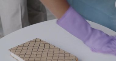 Kadın eli lastik eldivenli, ıslak bezle mobilyaların tozunu alırken kadın evini temizliyor. Ev işleri ve ev işleri konsepti.