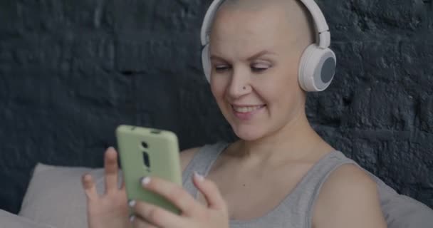 Веселая Беременная Женщина Слушает Музыку Наушниках Использует Смартфон Сидя Удобной — стоковое видео