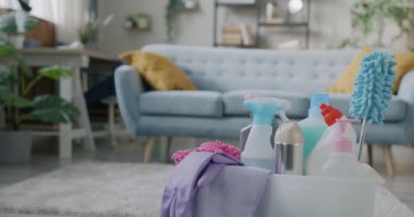 Modern bir dairede temiz bir oturma odası ve ön planda bir kutu temizlik malzemesi ve görülebilir insan yok. Oda servisi ve hijyen konsepti.