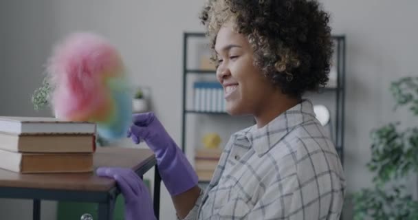 Joyful Afro Americano Mulher Prateleira Pulverização Com Espanador Colorido Limpando — Vídeo de Stock