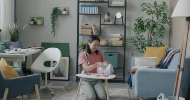 Kozmetik çanta temizleme dairesine makyaj malzemeleri toplayan neşeli Asyalı kadının portresi. Güzellik ve temizlik konsepti.