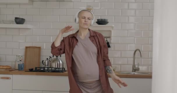 Lambat Gerak Wanita Hamil Gembira Mengenakan Headphone Menari Dapur Mendengarkan — Stok Video