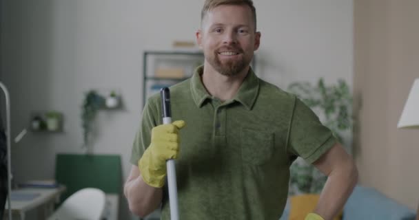 身着橡胶手套的男人慢动作肖像 微笑着拿着拖把准备在公寓做家务活 人与家务活概念 — 图库视频影像