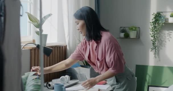 Vrolijke Aziatische Dame Opruimen Bureau Weg Zetten Papieren Briefpapier Geconcentreerd — Stockvideo
