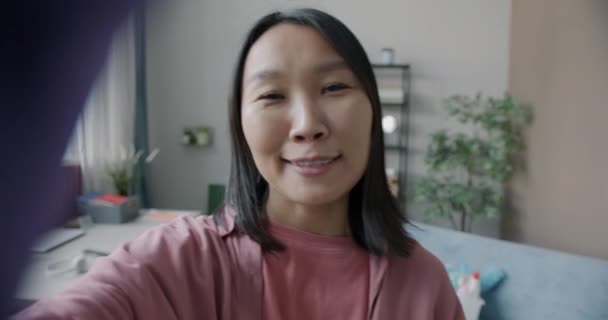 ハウスワークの後 クリーンなアパートを示すオンラインビデオ通話をする楽しいアジアの女性の肖像画 コミュニケーションと世帯のコアコンセプト — ストック動画