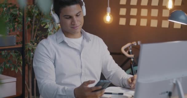 Arab Businessman Poslech Hudby Pomocí Sluchátek Smartphone Relaxaci Temné Kanceláři — Stock video