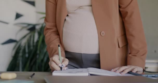 Gros Plan Femme Enceinte Écrivant Dans Cahier Debout Bureau Faisant — Video