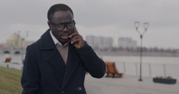 年轻的非洲裔美国人企业家在城市街道上用手机说话时的慢动作肖像 手机通信和商业概念 — 图库视频影像
