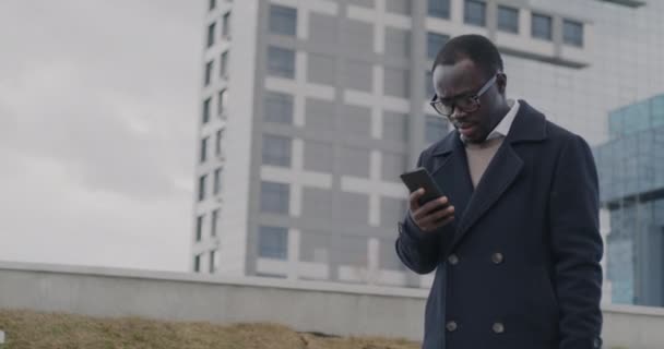 慢镜头下的非裔美国商人走在城市街道和检查智能手机消息 移动通信和商业概念 — 图库视频影像