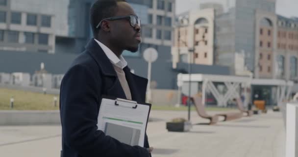 Медленный Портрет Афроамериканского Бизнесмена Документами Обращенными Камере Фоне Современного Города — стоковое видео