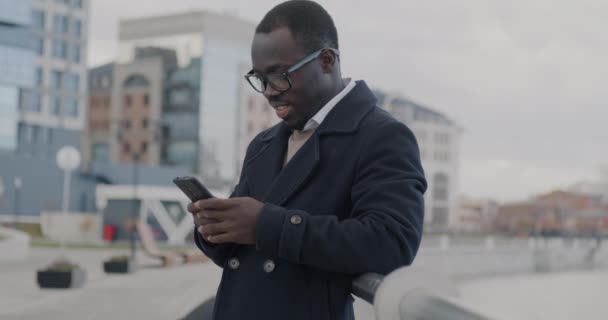 成功的非洲裔美国商人在城市街道上查看智能手机信息 然后转向户外相机的肖像 — 图库视频影像