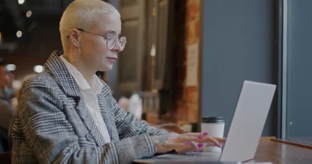 有动力的年轻女商人在现代咖啡店的室内用笔记本电脑打字 当代技术和企业家概念 — 图库视频影像
