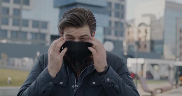 Powolny Portret Młodego Mężczyzny Zakładającego Maskę Patrzącego Kamerę Stojącą Zewnątrz — Wideo stockowe