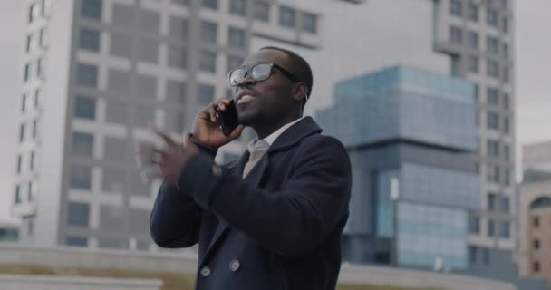 Optimistisk Afroamerikansk Affärsman Talar Mobiltelefon Gester Stående Moderna Stadsdelen Mobiltelefonkommunikation — Stockvideo