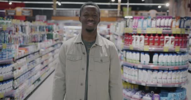 Африканський Американець Тримає Пластикові Пляшки Побутовими Хімікатами Стоять Супермаркеті Посміхаючись — стокове відео