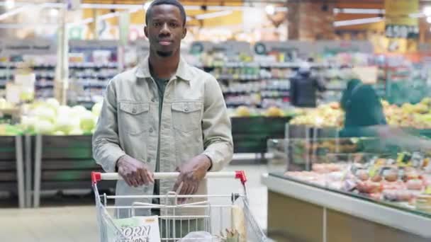 Portret Afroamerykanina Stojącego Współczesnym Supermarkecie Wózkiem Zakupy Kupującego Jedzenie Patrzącego — Wideo stockowe