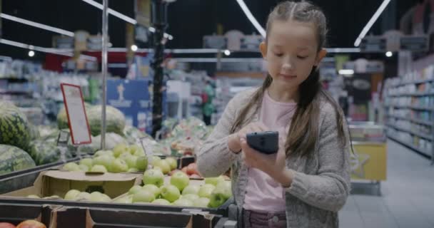 Süpermarkette Yiyecek Alışverişi Yapan Akıllı Telefon Ekranı Kullanan Küçük Tatlı — Stok video