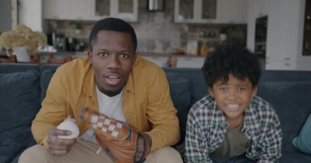 Afroamerikanischer Mann Schaut Baseballspiel Mit Kleinem Sohn Und Jubelt Bei — Stockvideo