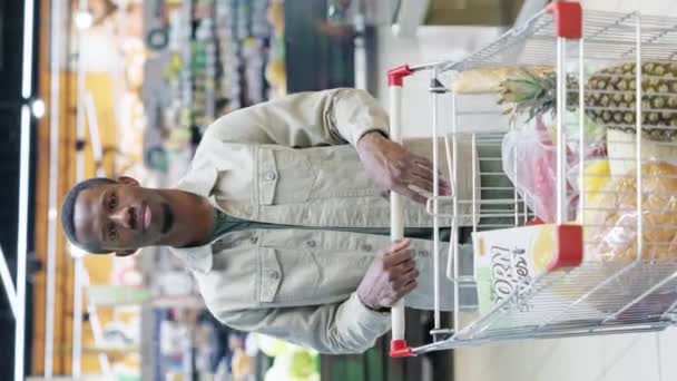 Vertikální Prošlý Portrét Afroamerického Kupce Stojícího Supermarketu Vozíkem Plným Potravinářských — Stock video