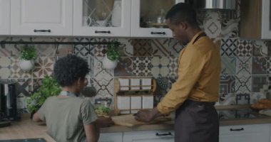 Mutlu baba ve çocuk öğle yemeği için sebze salatası yapıyor mutfakta birlikte yemek pişiriyorlar. Aile ve yemek konsepti.