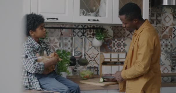Повільний Рух Афроамериканця Готує Овочевий Салат Розмовляє Сином Коли Хлопчик — стокове відео