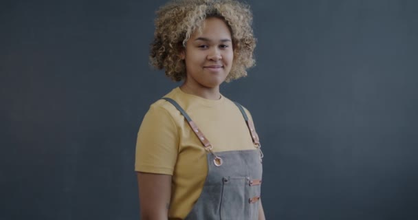 Retrato Cámara Lenta Alegre Joven Afroamericana Delantal Cruzando Brazos Sonriendo — Vídeo de stock