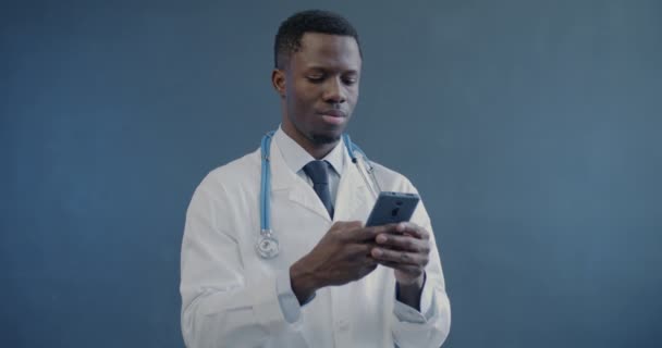 Porträt Eines Afroamerikanischen Arztes Laborkittel Mit Smartphone Sms Auf Grauem — Stockvideo