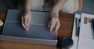 Masada bilgisayarla uğraşan bir kadının dizüstü bilgisayarı kullanışının en üst görüntüsü. Modern teknoloji ve bilişim endüstrisi kavramı.