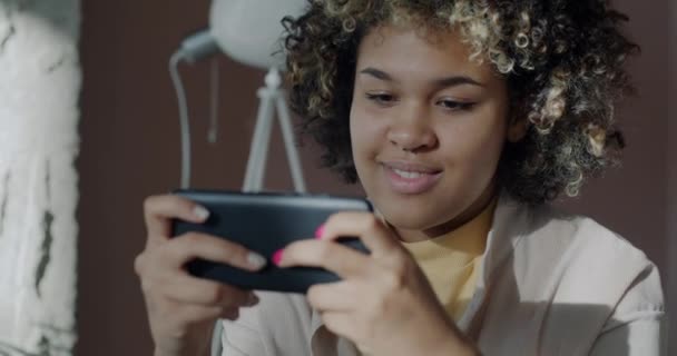 Mulher Afro Americana Alegre Jogando Videogame Online Com Smartphone Relaxante — Vídeo de Stock
