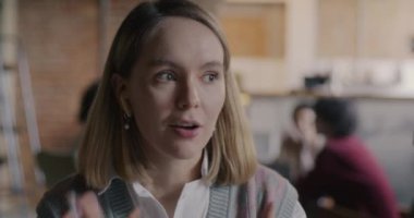 Güzel iş kadınının portresi kameraya bakıyor arka planda bulanık kafeyle online video görüşmesi yapıyor. Modern teknoloji ve iletişim konsepti.