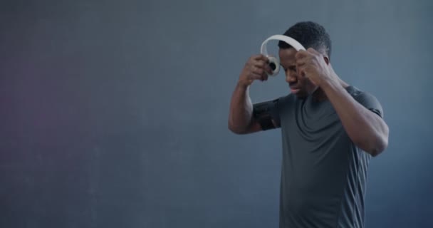 Africký Americký Sportovec Jogging Poslech Hudby Bezdrátovými Sluchátky Smartphone Fialovém — Stock video