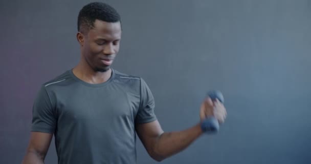 アフリカ系アメリカ人男性の肖像画は ダンベルで筋肉を鍛え 紫色の背景にリンゴの笑顔を食べる スポーツと健康的な栄養コンセプト — ストック動画