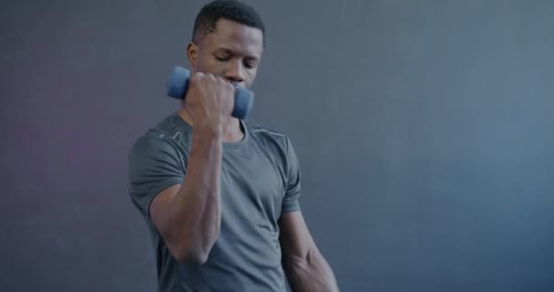 非洲裔美国健美运动员带哑铃运动的慢动作肖像集中在紫色背景的热身上 健美和体育概念 — 图库视频影像