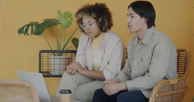 Genç çalışanlar, Afrikalı Amerikalı bayan ve Asyalı adam ofiste iş konuşuyorlar. Sanal toplantı ve başlangıç konsepti.