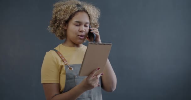 Afroamerykanka Cateringowa Właścicielka Firmy Mówi Przez Telefon Komórkowy Składając Zamówienie — Wideo stockowe