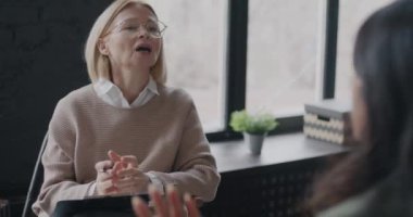 Profesyonel terapist, kadın müşteriyle konuşuyor. Ofiste hastayla çalışma sorununu tartışıyorlar. Terapi ve psikolog konsepti.