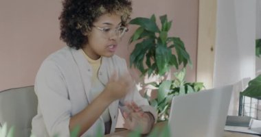 Genç Afrikalı Amerikalı iş kadını, bilgisayarlı bilgisayarla online video görüşmesi sırasında başlatılan projeyi konuşuyor. Sanal toplantı ve iş geliştirme kavramı.