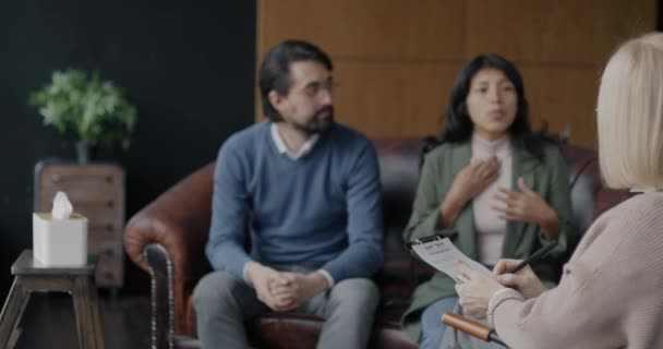 苦恼的年轻人不快乐的夫妇在现代办公室里与职业治疗师讨论家庭问题 人与关系危机概念 — 图库视频影像