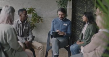 Psikiyatrist, takım çalışması sırasında psikoloji merkezinde çalışan bir grup insanla konuşuyor. Terapi ve toplum konsepti.