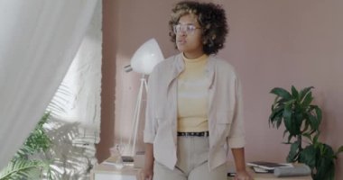 Modern ofiste kameraya bakarak gülümseyen kendinden emin Afrikalı Amerikalı bayan girişimcinin portresi. Hırslı kişi ve başarılı iş konsepti.