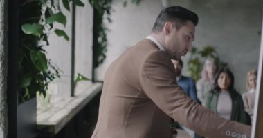 Koç güvertede yazıyor ve konferans veriyor. Seyirciler iş yerindeki seminerin keyfini çıkarırken. Modern koçluk ve eğitim kavramı.